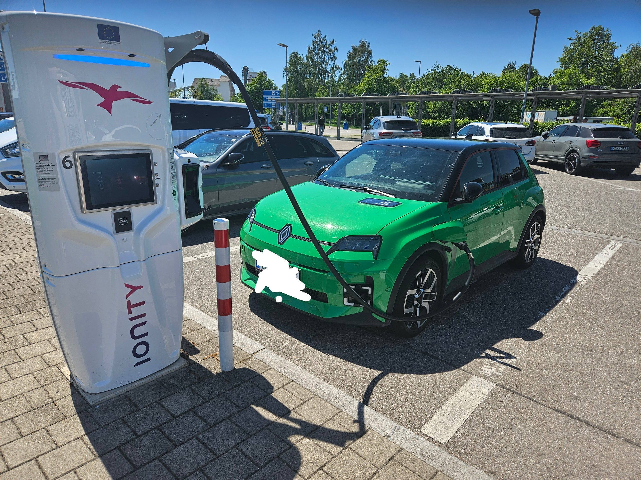 Ein grüner Renault 5 an einer Ionity-Ladesäule unter brennender Sonne